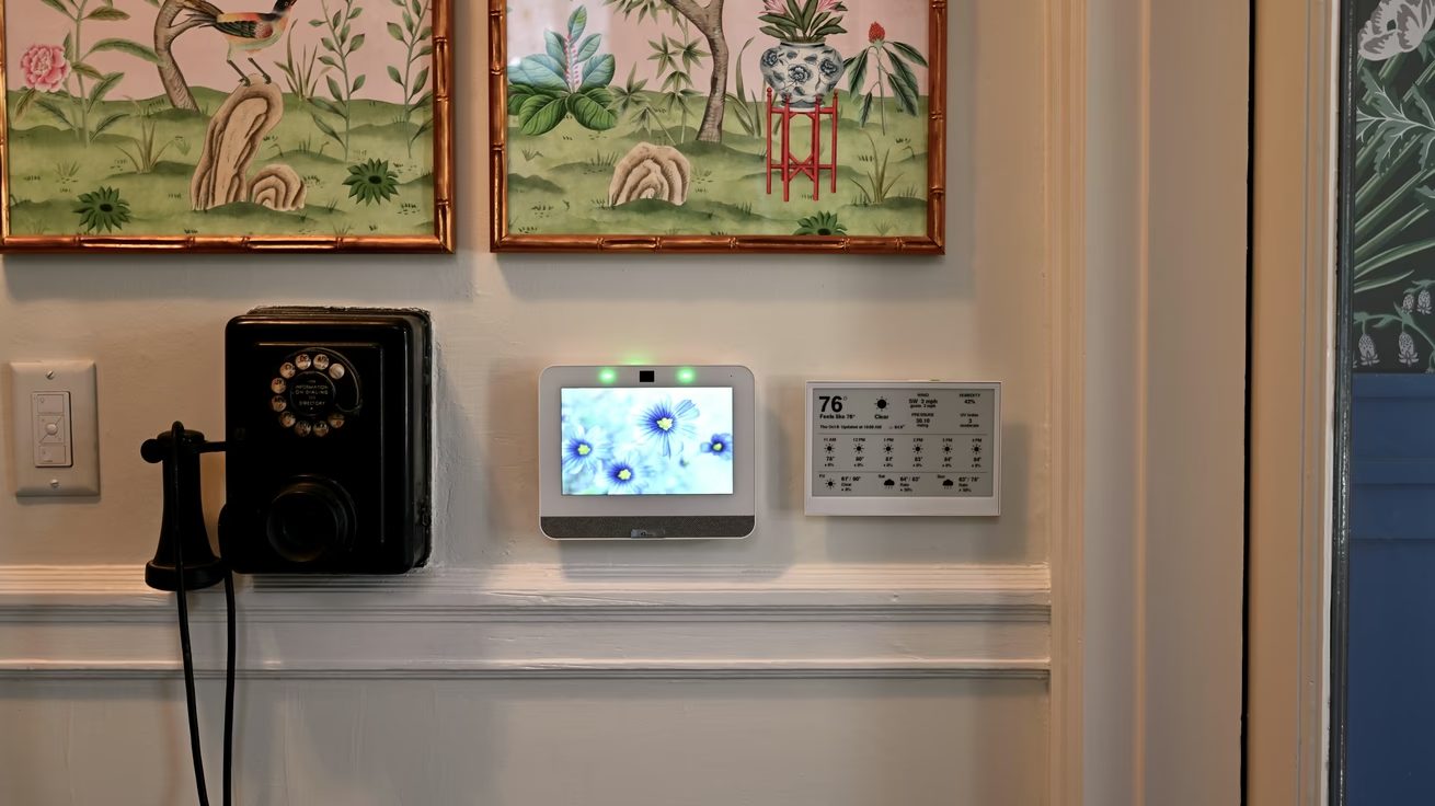 Bogost’s homemade black-and-white weather display mounted on a wall beside an antique wall telephone and a smart-home screen